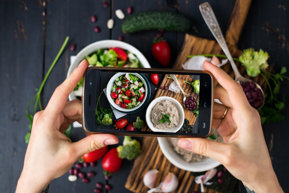 Person photographing food with smartphone