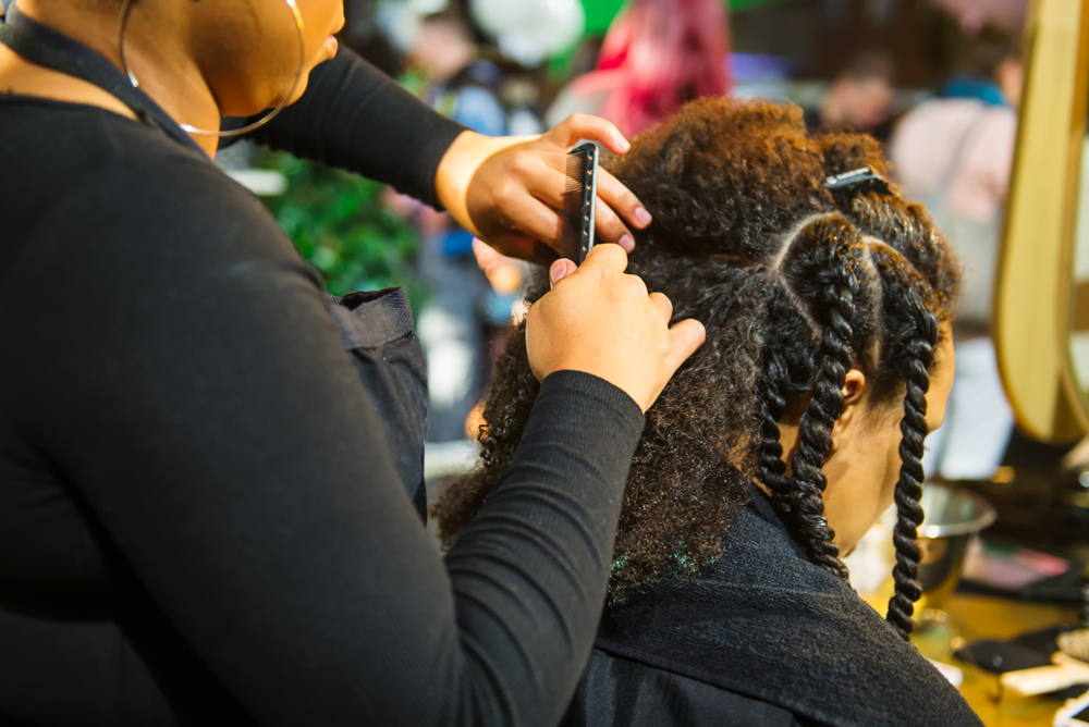hairstylist braiding afro-textured hair