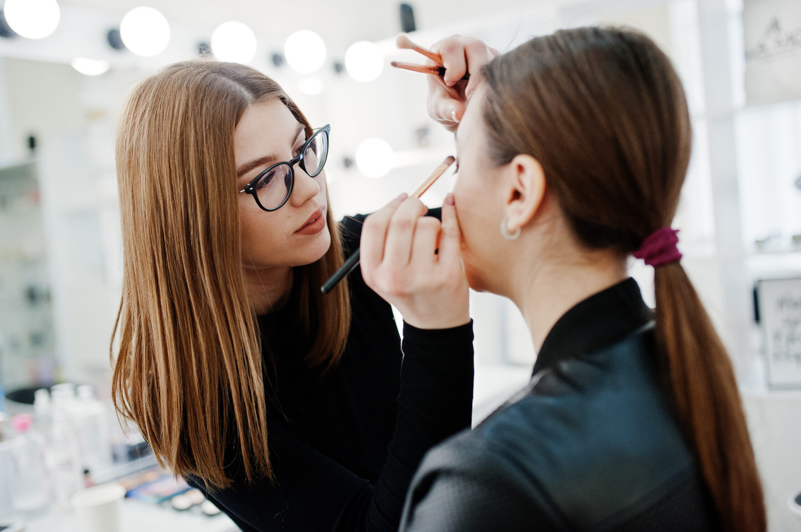 makeup artist applying makeup to woman